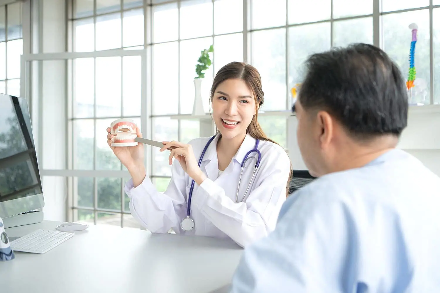 A dentist talks about braces treatment to a seated patient in a dental office and getting free orthodontic consultation at Farr Orthodontics in Georgetown, TX.