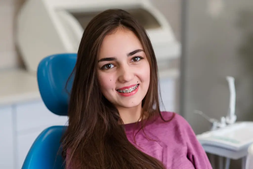 A young woman with long brown hair and braces in Georgetown, TX.