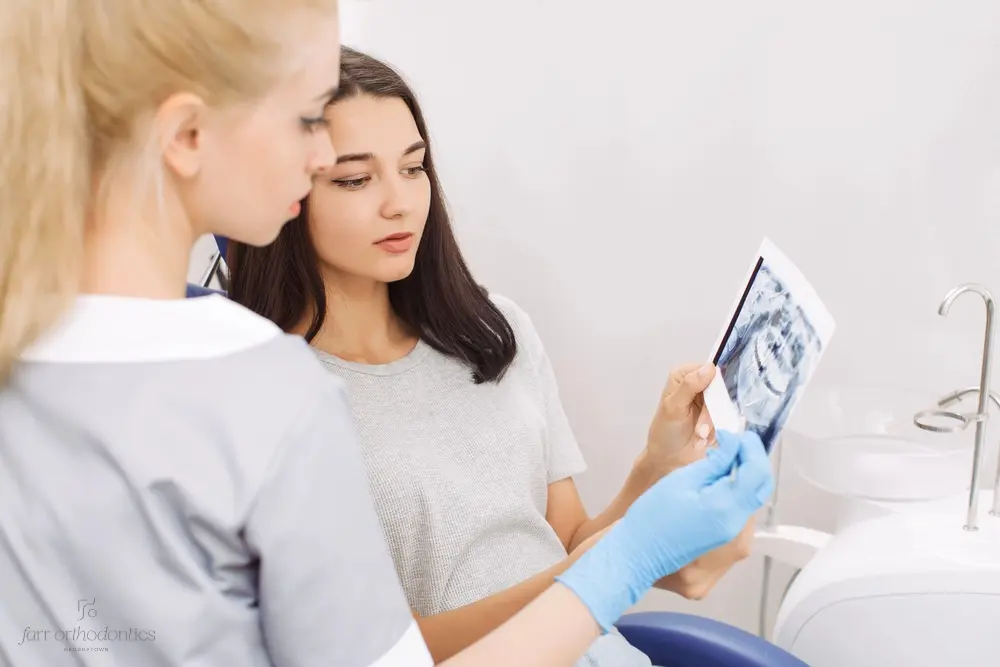 Female dentist showing dental X-rays to a young woman during a consultation about how to fix overbite in georgetwoen, tx.