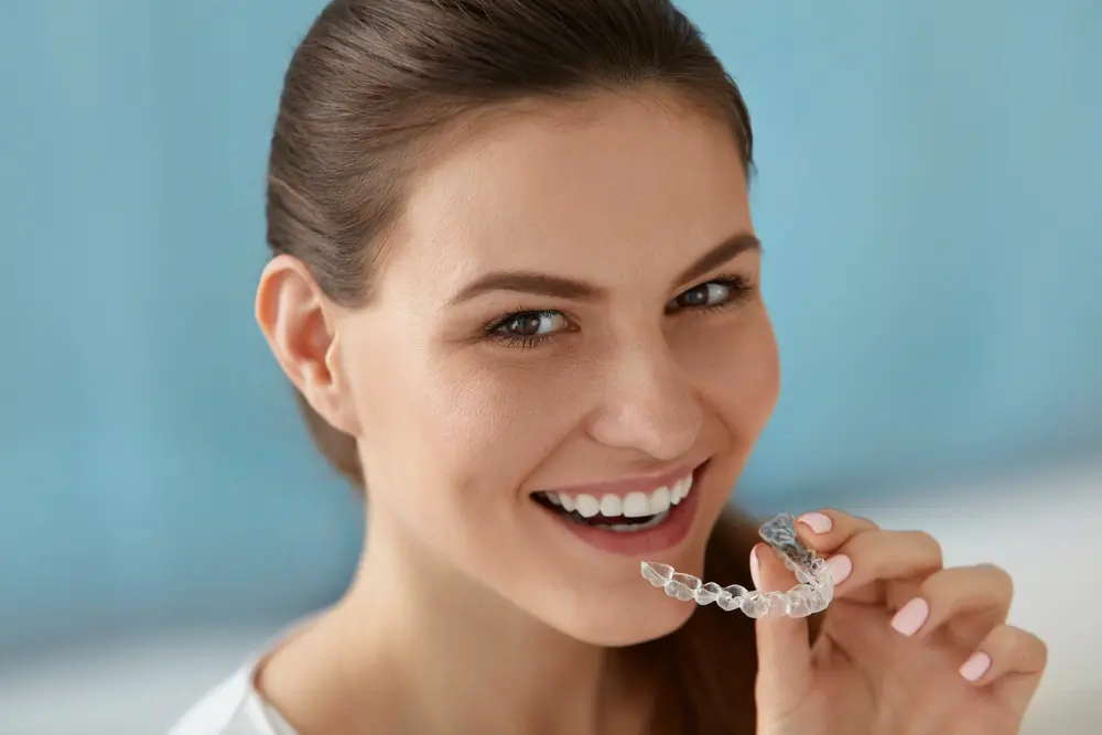 dental care smiling woman using invisalign clear aligners - Can Invisalign Fix Overbite in Georgetown, TX. 