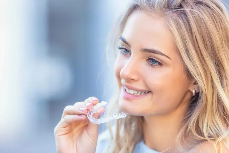 young attractive woman holding invisalign clear aligners - Can Invisalign Fix Overbite in Georgetown, TX.