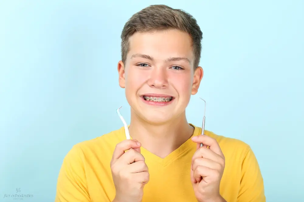 young man with metal braces toothbrush dentist tool - How to Floss with Braces in Georgetown, TX. 