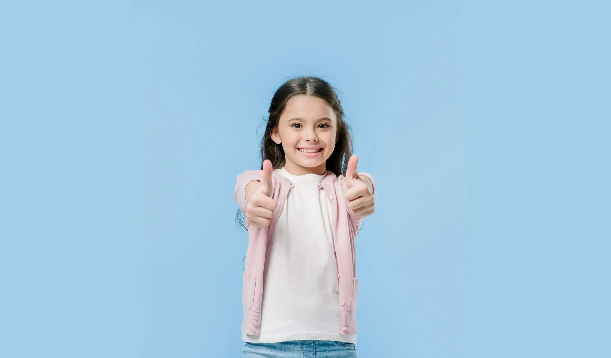 Smiling girl with long dark hair gives thumbs up, showing affordable braces from Farr Orthodontics in Georgetown, TX.