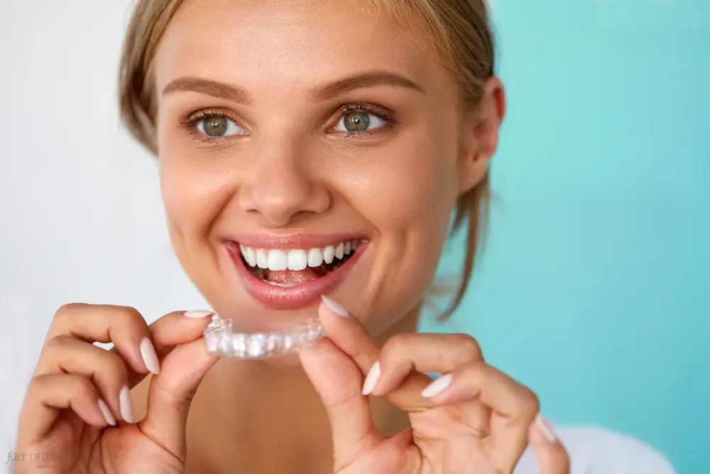 smiling woman with beautiful smile using invisalign clear aligners - How Does Invisalign Work in Georgetown, TX 